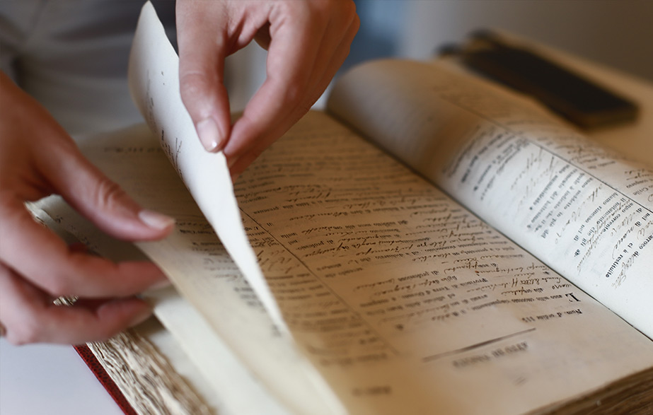 archivio e città il progetto archivio storico comune di lecce Mani di una persona che sfoglia un libro nel processo di digitalizzazione dell'archivio storico